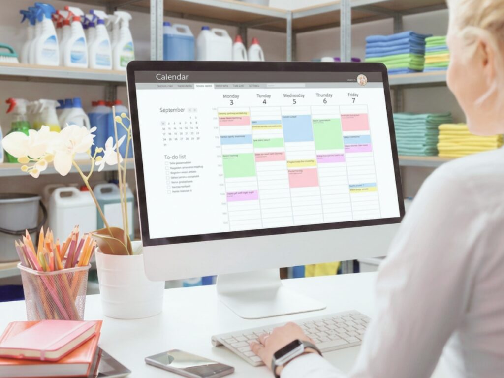 edmonton residential cleaning service office with scheduling software on computer screen and shelves with cleaning supplies and cloths 